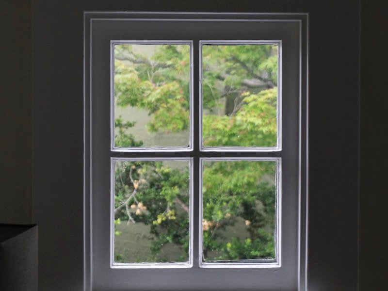 A clean multi-pane white window unit set in a dark wall